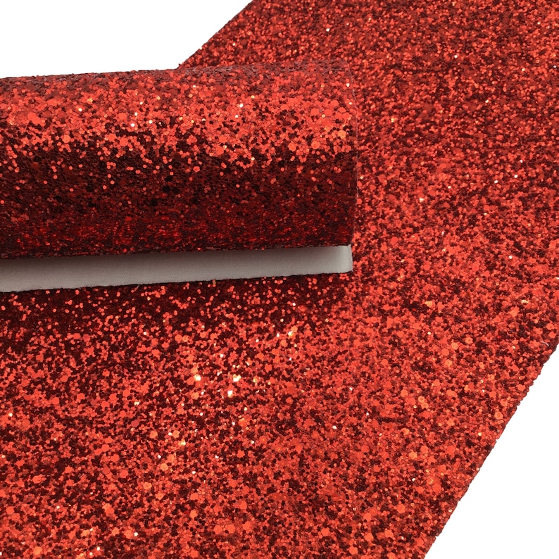 Op de afbeelding: Rood glitterstof vel. Het vel is gemaakt van een zacht, flexibel materiaal en heeft een glinsterend, textuur oppervlak.