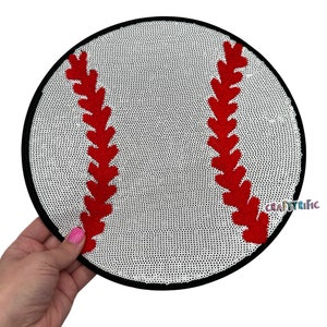 May include: A white baseball with red stitching, embroidered on a white mesh fabric. The baseball is surrounded by a black border.