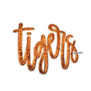 May include: Orange sequined "Tigers" patch with a white border. The word "Tigers" is written in a cursive font. The patch is on a white background. The word "craftyrific" is written in the bottom right corner.
