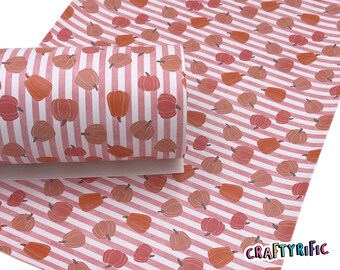 May include: Pink and white striped fabric with a repeating pattern of orange pumpkins. The fabric is rolled up and the text "CRAFTYriFic" is visible in the bottom right corner.