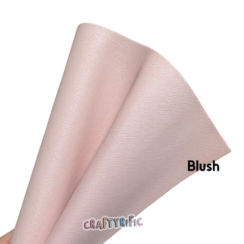 May include: A folded sheet of blush-colored faux leather with a textured surface. The word "Blush" is printed in black on the right side of the sheet. The brand name "CRAFTYRIFIC" is printed in pink and white at the bottom.