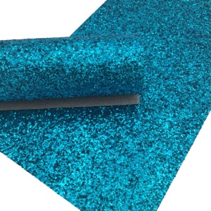 May include: A sheet of turquoise glitter fabric. The fabric is covered in small, sparkly glitter.