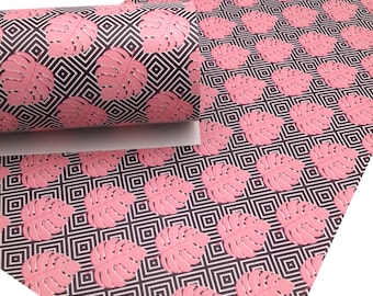 May include: Pink and white tropical leaf patterned faux leather with a geometric design. The pattern is repeated throughout the fabric.