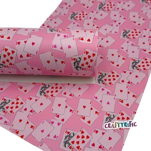 May include: Pink playing card-themed faux leather sheet with a repeating pattern of hearts. The cards are white with red heart suits and black card details. The text "CRAFTYrific" is visible in the lower right corner.