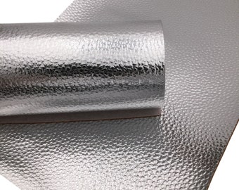 May include: A roll of silver faux leather with a textured, bubbled surface. The leather is rolled up and the end is visible.