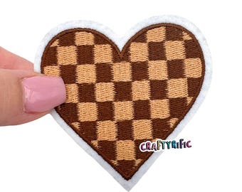 May include: Brown and tan checkered heart-shaped embroidered patch with a white border. The patch has the text "CRAFTYRIFIC" in the bottom right corner.
