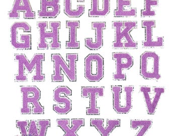 Puede incluir: Un conjunto de 26 parches de letras de fieltro morado con contorno plateado. Las letras están en mayúsculas y están ordenadas alfabéticamente.