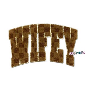 May include: A brown and gold patch with the word "WIFEY" in a varsity-style font. The letters are a dark brown checkered pattern with gold glitter accents. The patch has a curved shape and a white background.