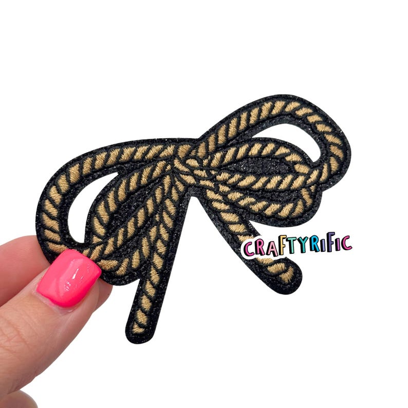 K&ouml;nnte beinhalten: Gestickter Aufn&auml;her mit einem Seil-Design in Schwarz und Beige. Der Aufn&auml;her wird von einer Hand gehalten. Der Text "CRAFTYRIFIC" ist auf dem Aufn&auml;her zu sehen.