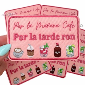 May include: Pink embroidered iron-on patch with the text "Por la Mañana Cafe Por la tarde ron" and illustrations of coffee, a cocktail, rum, and a mojito.