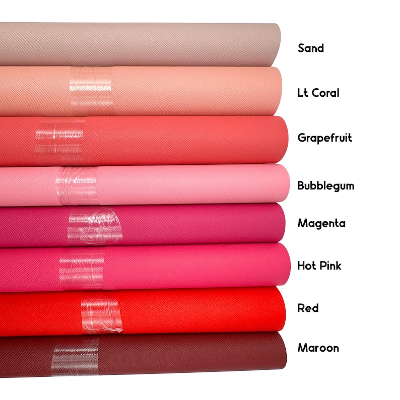 May include: A stack of fabric rolls in various shades of pink, red, and brown. Colors include sand, Lt Coral, Grapefruit, Bubblegum, Magenta, Hot Pink, Red, and Maroon. Each roll is labeled with its color name.