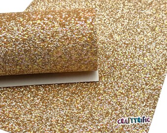 May include: A sheet of gold glitter fabric with a rolled edge. The glitter is densely packed, creating a sparkling effect. The CraftyRific logo is visible in the bottom right corner. This material is suitable for crafts and DIY projects.