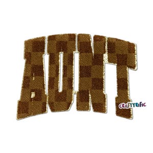 May include: Brown and gold embroidered patch spelling the word "AUNT" in a varsity letter style. The letters have a checkered pattern and gold trim. The bottom right corner has the text "CRAFTYrific".