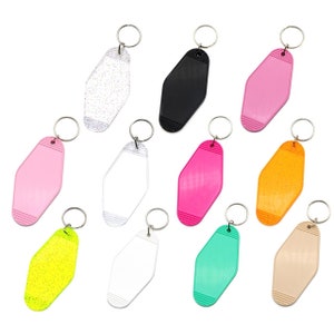May include: Ten different colored keychains with a motel key shape. The keychains are made of plastic and have a silver metal ring. The colors include pink, white, black, orange, green, yellow, and beige.