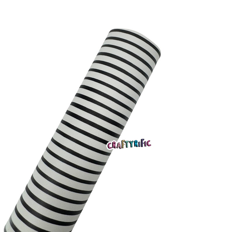 May include: A roll of white material with black horizontal stripes. The material is tightly rolled and angled towards the upper left corner. The text "CraftyRific" is printed in the lower right corner.