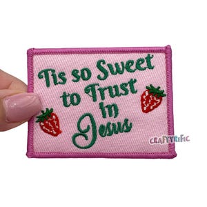 May include: Pink embroidered patch with the text "Tis so sweet to trust in Jesus" and two red strawberries.