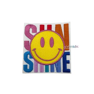May include: Embroidered iron-on patch with a rainbow colored "Sunshine" text and a yellow smiley face in the center.