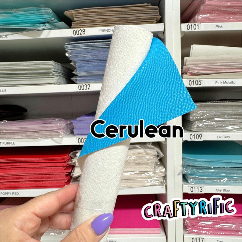 May include: A roll of white textured material with a cerulean blue backing is displayed. The word "Cerulean" is written on the image. The background shows shelves with various colored papers, including pink, teal, and purple.