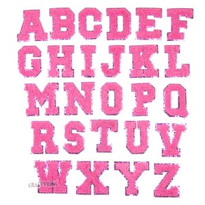 May include: Pink felt alphabet letters with a white outline. The letters are arranged in alphabetical order.