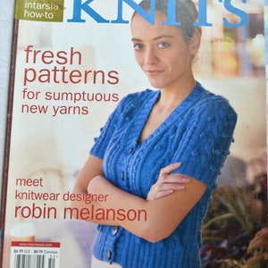 May include: A magazine cover for Interweave Knits, Spring 2006 issue. The cover features a woman wearing a blue knitted sweater with a cable stitch pattern. The text on the cover reads "fresh patterns for sumptuous new yarns" and "meet knitwear designer robin melanson".