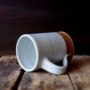 Handmade thrown mug with rustic styling. Each piece is handmade and unique made in America. White glaze and brown clay.
