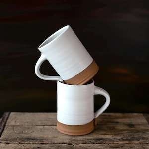 Handmade thrown mug with rustic styling. Each piece is handmade and unique made in America. White glaze and brown clay.