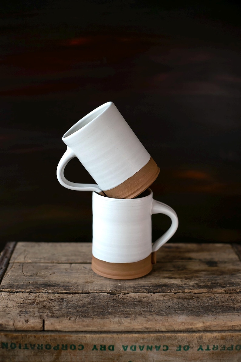 Handmade thrown mug with rustic styling. Each piece is handmade and unique made in America. White glaze and brown clay.