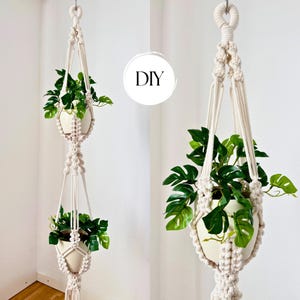 May include: A double-tiered off-white macrame plant hanger featuring intricate knotted cord patterns. The hanger holds two cream-colored pots, each containing a green monstera plant. The text DIY is visible in a white circle in the center.