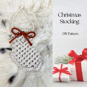May include: A white crocheted Christmas stocking ornament with a red bow. The ornament is on a white fluffy surface. The text "Christmas Stocking DIY Pattern" is on the right side of the image.