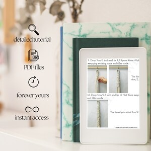 May include: A digital tablet displaying a step-by-step tutorial for making a macrame wall hanging. The tutorial includes instructions for tying square knots and half knots, and the text mentions dropping 5 cm/2 inches and 6 cm/2.5 inches of cord.