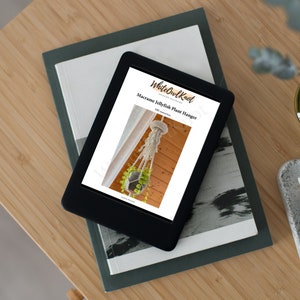 May include: A digital download for a macrame jellyfish plant hanger DIY project. The image shows a white macrame plant hanger with a green plant in a pot hanging from a wooden ceiling. The text on the page reads "White Owl Knot" and "Macrame Jellyfish Plant Hanger".