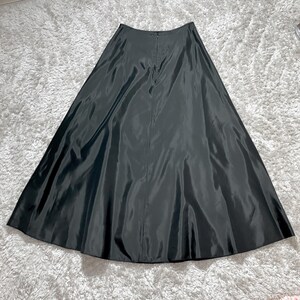 May include: A long, black skirt made of a shiny, flowing fabric. The skirt has a high waist and a full, A-line silhouette. The back of the skirt features a zipper closure. The skirt is suitable for formal occasions.