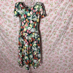 May include: A short-sleeved dress with a floral print featuring colorful tulips on a dark green background.