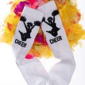 May include: White socks with black cheerleading silhouette and the word "CHEER" on each sock. The socks are surrounded by a colorful flower garland.