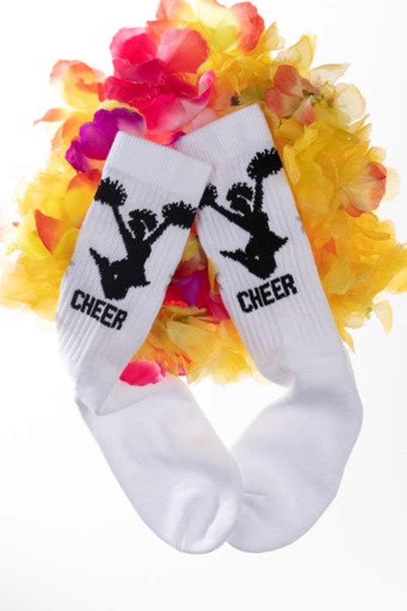 May include: White socks with black cheerleading silhouette and the word "CHEER" on each sock. The socks are surrounded by a colorful flower garland.