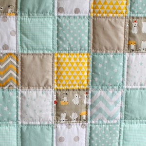May include: A patchwork quilt with a variety of patterns in shades of gray, white, yellow, and light blue. The patterns include polka dots, stars, chevron, and geometric shapes.