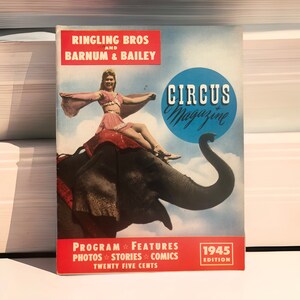 May include: A vintage circus magazine cover featuring a woman in a red and gold costume riding an elephant. The cover is red, white, and blue with the text "Ringling Bros and Barnum & Bailey Circus Magazine 1945 Edition".