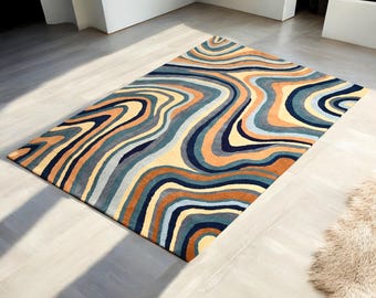 May include: Abstract rug with a swirling pattern in shades of blue, orange, yellow, and brown. The rug has a contemporary design and would add a touch of modern style to any room.