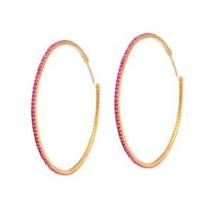 Op de afbeelding: Een paar gouden oorringen met een roze stenen rand.