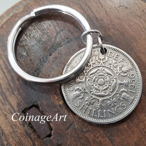 May include: Silver key chain with a 1969 two shilling coin featuring a rose and the text "Two Shillings" and "DEF 1969".