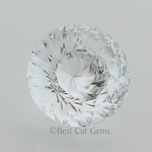 May include: A clear, faceted gemstone with a star-shaped pattern in the center. The gemstone is round and has a high polish.  ©Best Cut Gems