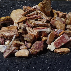 May include: A pile of raw, natural stones in various shapes and sizes. The stones display a mix of colors, including shades of red, brown, white, and yellow. The textures vary from smooth to rough, with visible mineral striations.