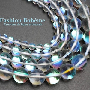 Peut inclure: Un brin de perles de verre claires irisées. Les perles sont rondes et ont un reflet arc-en-ciel. Les perles sont enfilées sur un fil blanc.