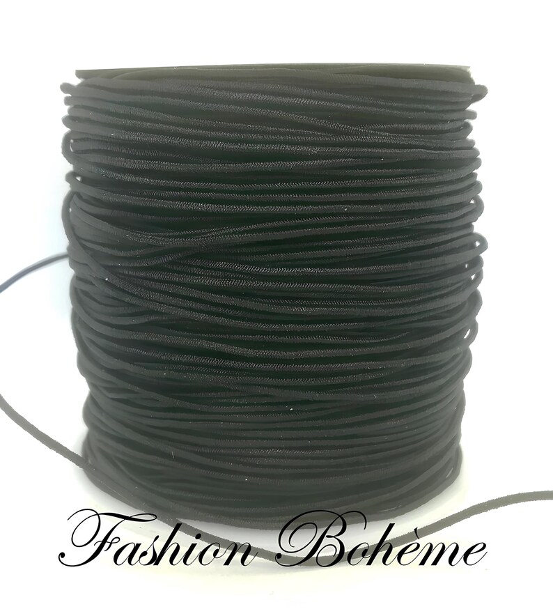 May include: A spool of black elastic cord. The cord is tightly wound, showing a textured surface. The words "Fashion Boh&egrave;me" are written in a cursive font at the bottom of the image.