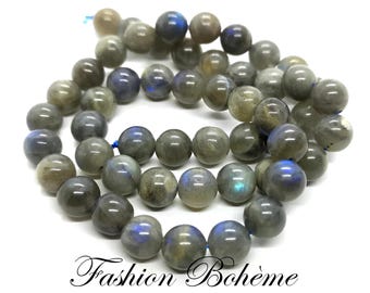 May include: A strand of gray and blue labradorite gemstone beads. The beads are round and smooth, and they have a slight iridescent sheen.