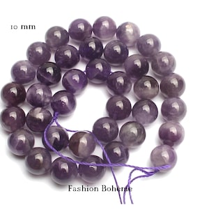 Peut inclure: Un brin de perles rondes d'améthyste de 10 mm, enfilées sur un fil violet. Les perles sont d'une couleur violet foncé et ont une finition lisse et polie.
