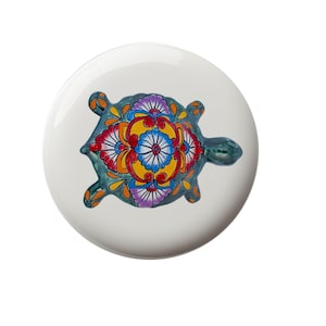 May include: A ceramic turtle figurine with a green shell and colorful floral designs. The turtle is painted with red, yellow, blue, and white flowers.