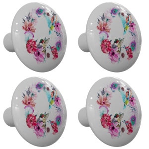 May include: Four white ceramic cabinet knobs with a floral design featuring pink, purple, and blue flowers, green leaves, and hummingbirds. The knobs have a silver metal stem.