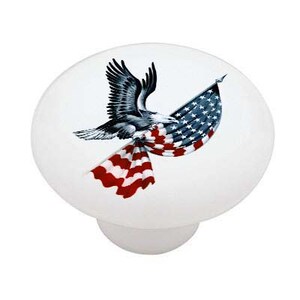 May include: A ceramic knob with a white background and a design of a bald eagle flying with an American flag draped over its wings.
