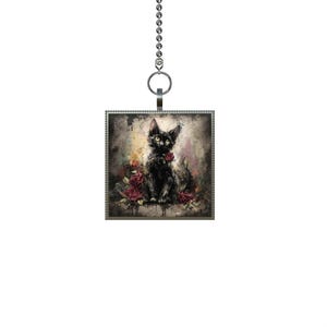 May include: Square pendant featuring a black cat with yellow eyes and a red rose, surrounded by red roses. The pendant is attached to a silver chain with a ring at the top. The artwork has a painterly style with a dark, moody aesthetic.